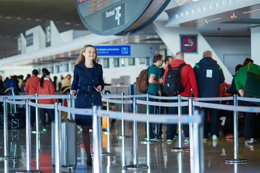 Young woman in international airport, walking with her luggage