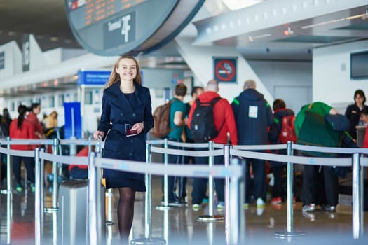 Young woman in international airport, walking with her luggage