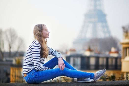 Beautiful young girl outdoors near the Eiffel tower, in Paris