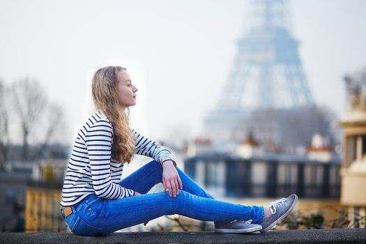 Beautiful young girl outdoors near the Eiffel tower in Paris, France