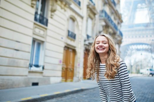 Beautiful young girl outdoors near the Eiffel tower, in Paris