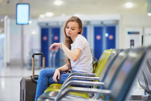 Young woman in international airport waiting for her flight