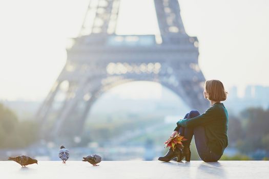 Beautiful young girl in Paris near the Eiffel tower at morning