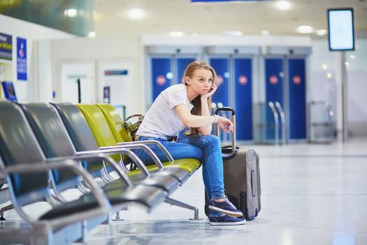 Young woman in international airport waiting for her flight