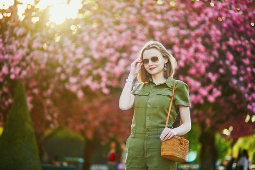 Beautiful French woman walking in Paris on a spring day at cherry blossom season