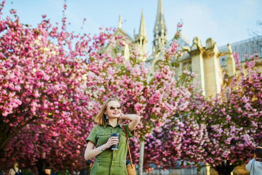 Beautiful French woman walking in Paris on a spring day at cherry blossom season