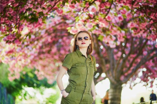 Beautiful French woman walking in Paris on a spring day at cherry blossom season