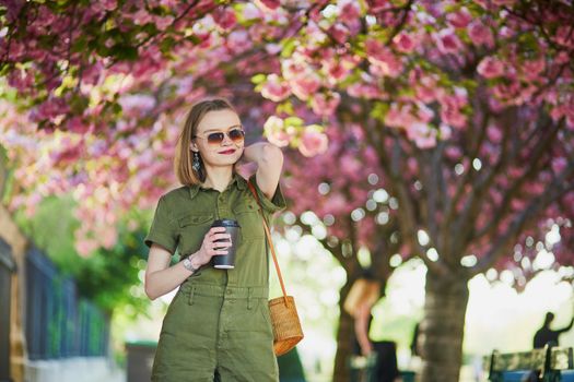 Beautiful French woman walking in Paris on a spring day at cherry blossom season