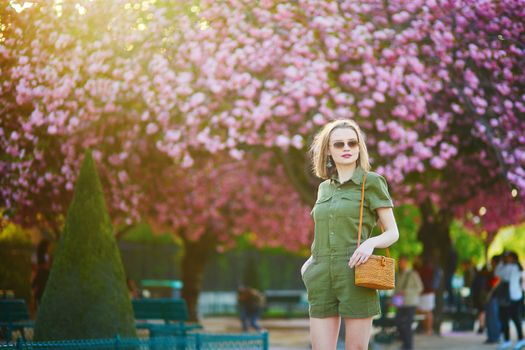 Beautiful French woman walking in Paris on a spring day at cherry blossom season