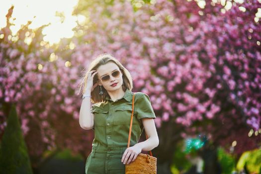 Beautiful French woman walking in Paris on a spring day at cherry blossom season