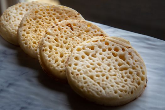 Hot toasted English crumpets arranged in a line