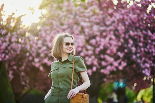 Beautiful French woman walking in Paris on a spring day at cherry blossom season