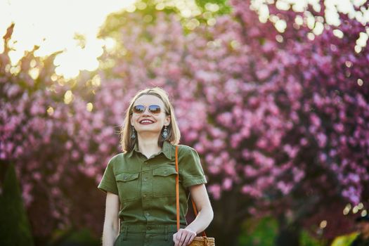 Beautiful French woman walking in Paris on a spring day at cherry blossom season