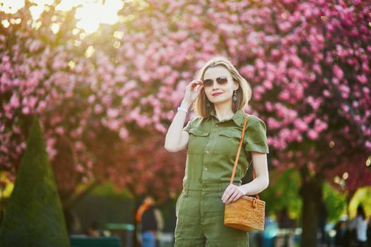 Beautiful French woman walking in Paris on a spring day at cherry blossom season
