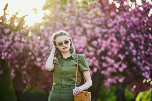 Beautiful French woman walking in Paris on a spring day at cherry blossom season