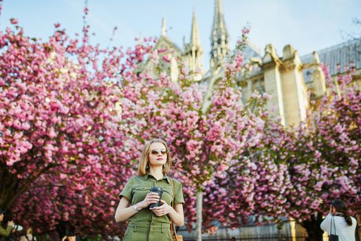 Beautiful French woman walking in Paris on a spring day at cherry blossom season