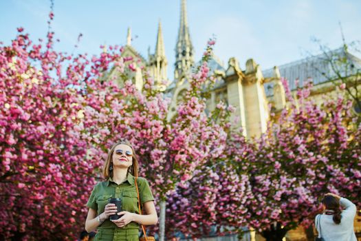 Beautiful French woman walking in Paris on a spring day at cherry blossom season