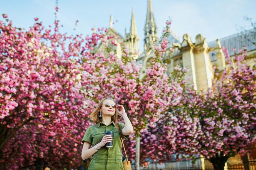 Beautiful French woman walking in Paris on a spring day at cherry blossom season