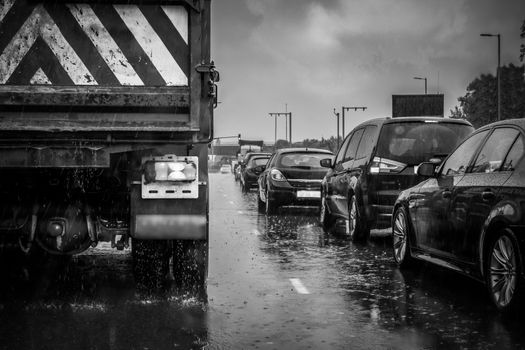 An image of traffic on a London road in heavy rain.