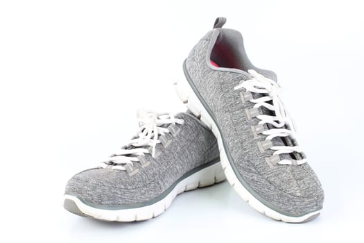 Gray sneakers with red laces on a white background