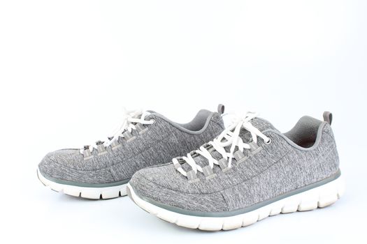 Gray sneakers with red laces on a white background