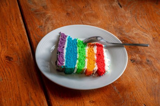A slice of multi layered rainbow cake