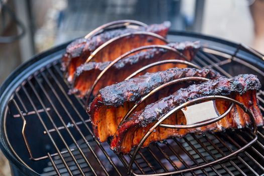 Cooking marinated baby back ribs on an outdoor barbecue