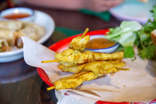 Chicken satay on wooden skewers with peanut sauce