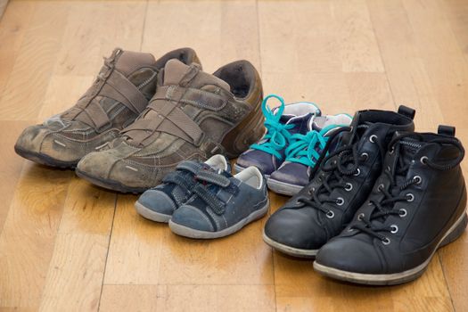 Family shoes In a row on a wooden floor