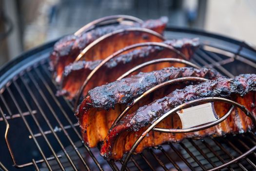 Cooking marinated baby back ribs on an outdoor barbecue