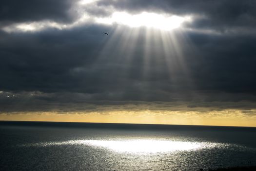 A shaft of light breaking through the dark clouds.  Provides imagery of hope, faith, religion