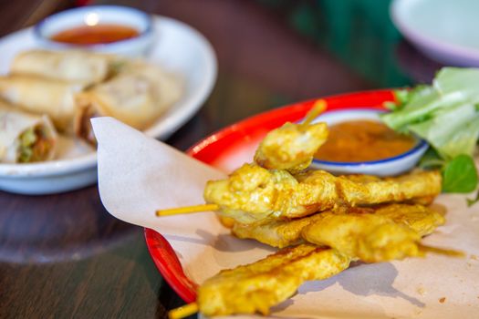 Chicken satay on wooden skewers with peanut sauce