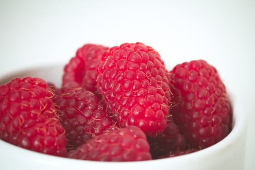 A pile of raspberries, Rubus idaeus, in a white bowl