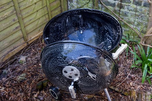 Cleaning a kettle drum barbecue with sopay water