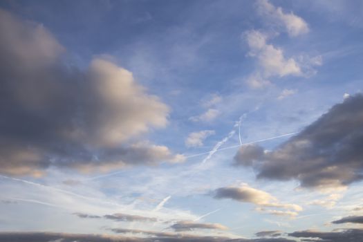 Dark clouds and aeroplane trails in a blue sky