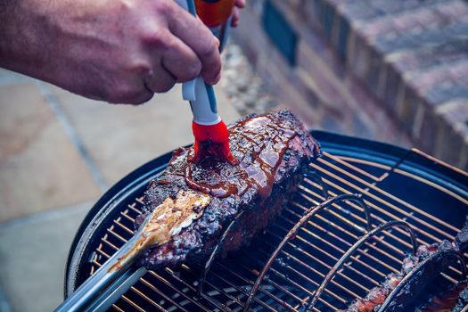 Cooking marinated baby back ribs on an outdoor barbecue