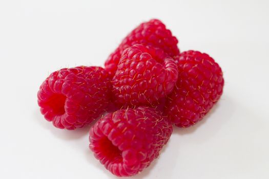 Pile of raspberries on a white background