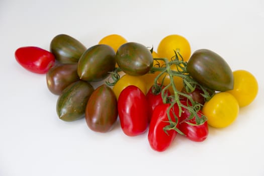 A variety of multi-coloured tomatoes on a white background