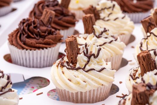 An assortment of homemade chocolate and vanilla cupcakes with a chocolate flake