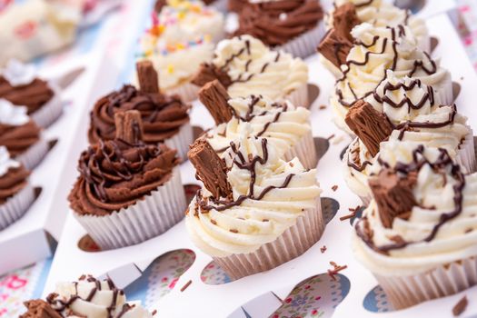 An assortment of homemade chocolate and vanilla cupcakes with a chocolate flake