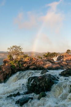 Top of the Ruacana waterfall in the Kunene River. A rainbow is visible