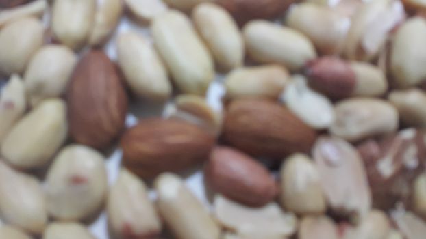 Closeup view of mixed dried and roasted  peanuts and almonds. A fruit for background text