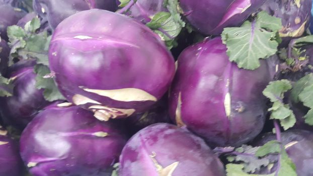 Fruits background: Purple fresh kohlrabi turnip in supermarket for sale.