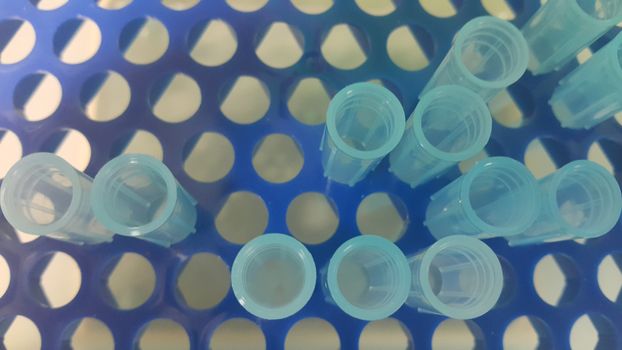 Close up view of blue micro litre tips in microtip box with empty holes. Reseach lab. tool for accurate measurement.