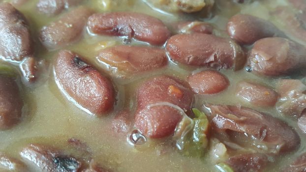 Kidney beans dish:  Closeup view of cooked red kidney beans dish. Dark red useful beans dish background.