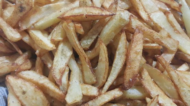 Closeup view of potato french fries or roasted potato sticks  with copy space for text