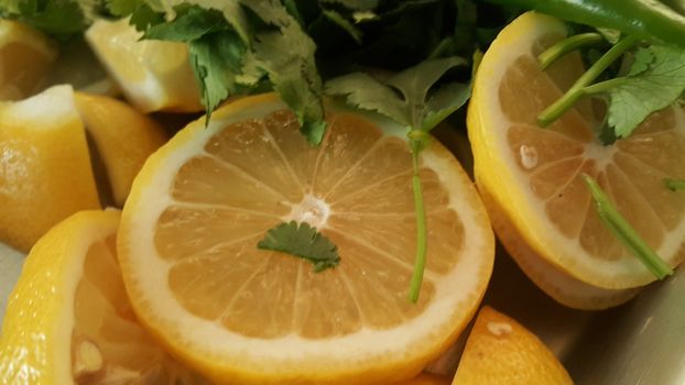 Top view of fresh lemon slices with green pepper cut into pieces for salad. Fruit background