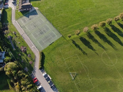 drone view of a park and hedges and trees in low evening sunshine 