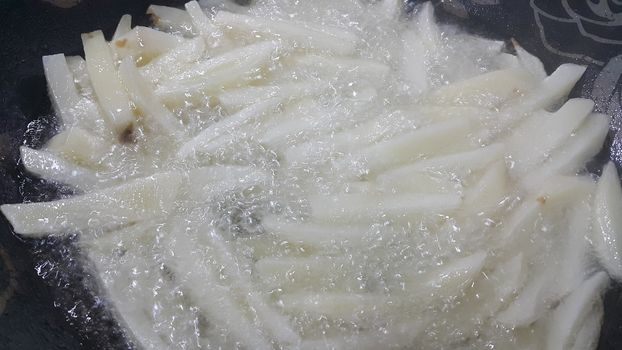 Closeup view of uncooked potato french fries or potato sticks with copy space for text