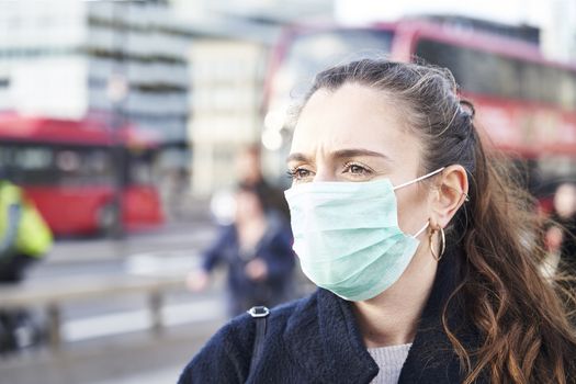 Young woman wearing face mask while walking in the streets of London